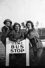 Women Marines around sign, circa 1944. Three Women Marines pose around a sign at Camp Lejeune that reads "U.S.M.C. Bus Stop." The women wear olive-drab work overalls, men's work jackets, and "daisy mae" fatigue hats.  Nina Johnson Wiglesworth Papers Collection (WV0132.6.008), Betty H. Carter Women Veterans Historical Project, University of North Carolina at Greensboro, NC.
